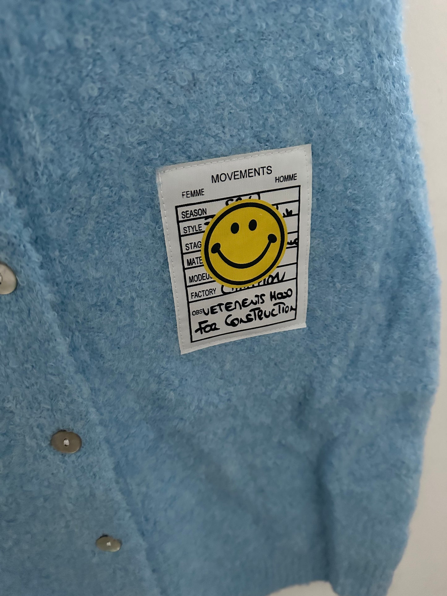 Hellblaue Weste mit Smiley-Detail